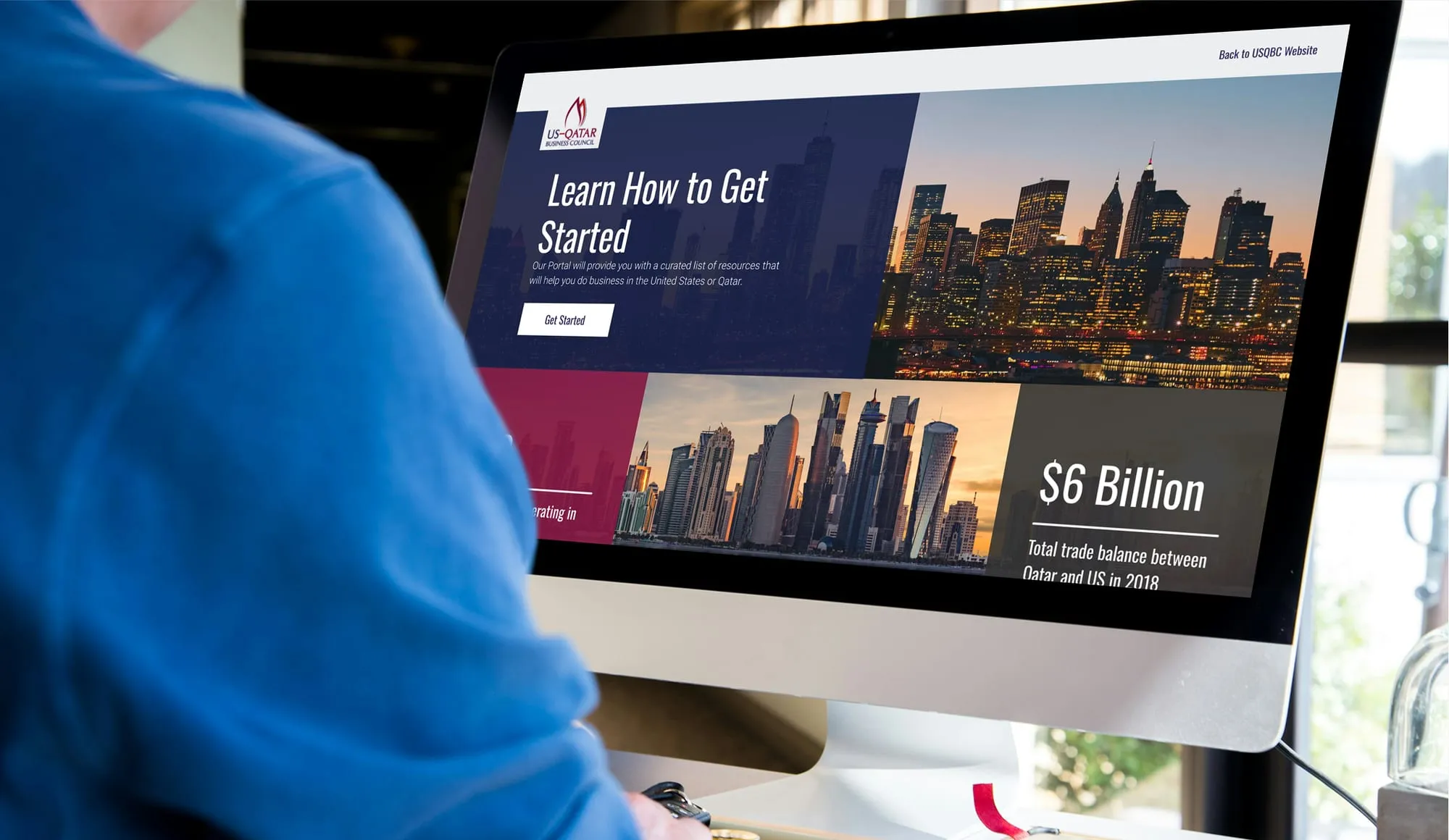 A person at a desktop computer viewing the USQBC Business Portal, with a Learn How to Get Started page, a Get Started button and a trade figure.