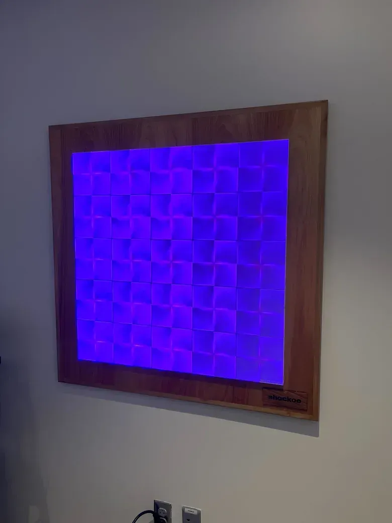 The wall display glowing blue in a wooden frame on a wall.
