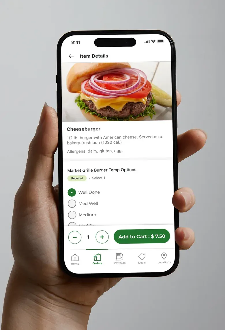 A hand holding a phone showing a Fast & Fresh item details screen for a cheeseburger with options and an Add to Cart button.