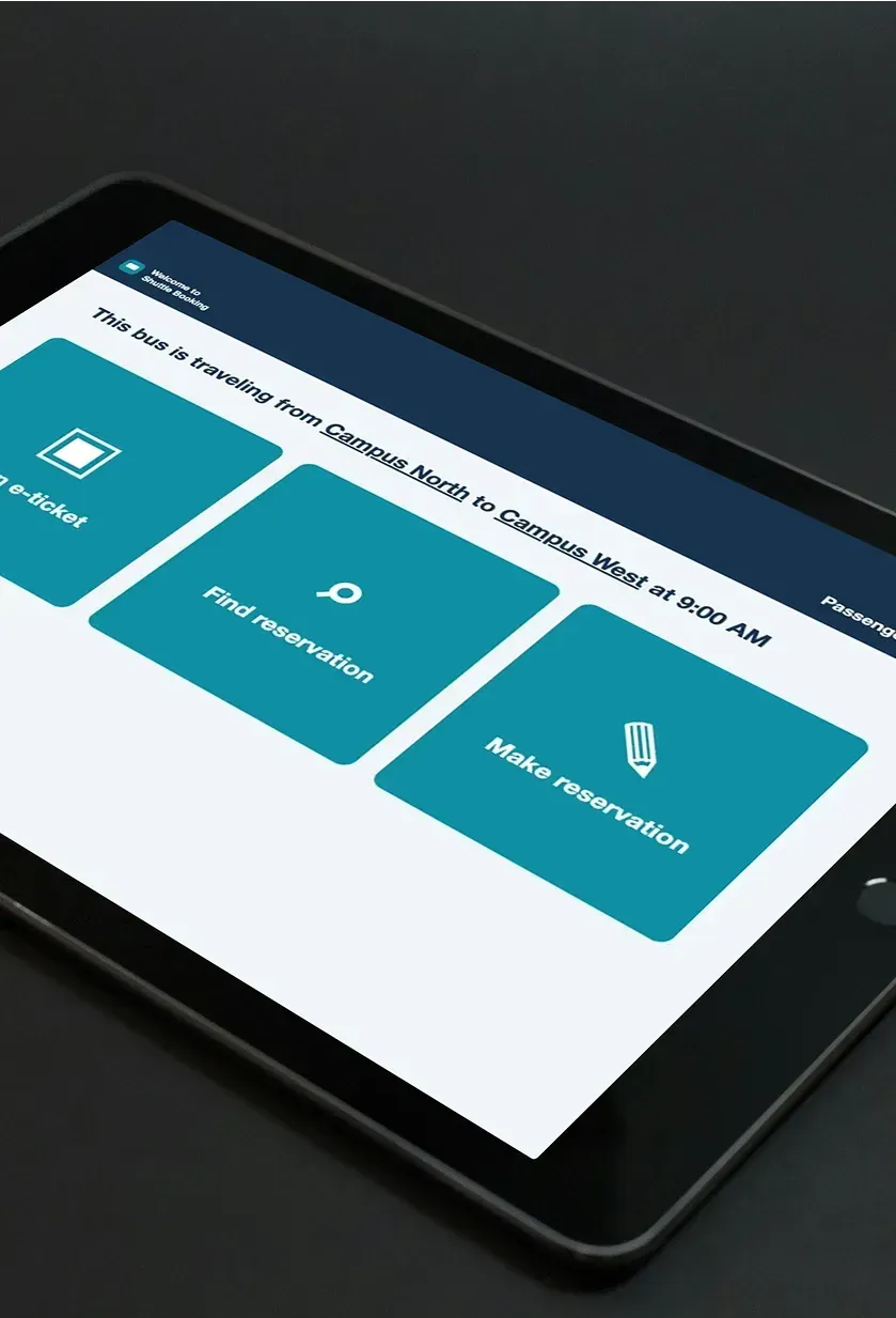 A tablet showing the bus kiosk check-in screen with buttons to scan an e-ticket, find or make a reservation.