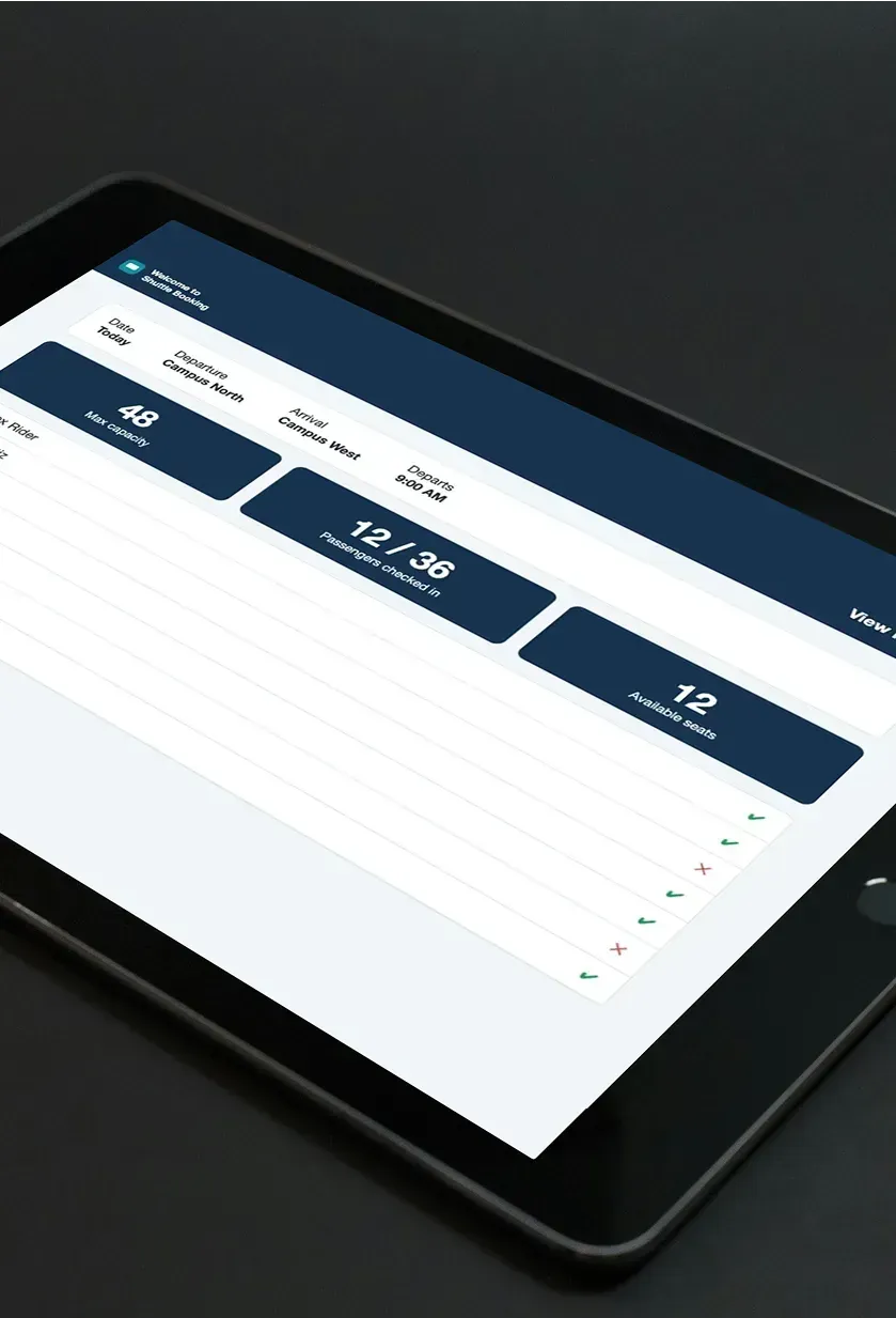 A tablet showing the bus kiosk passenger list with capacity, passengers checked in and available seats.