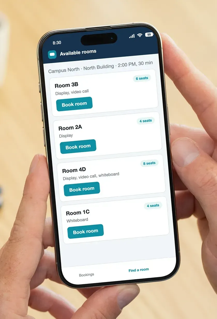 A phone showing a list of available rooms with seat counts, features and a Book room button.