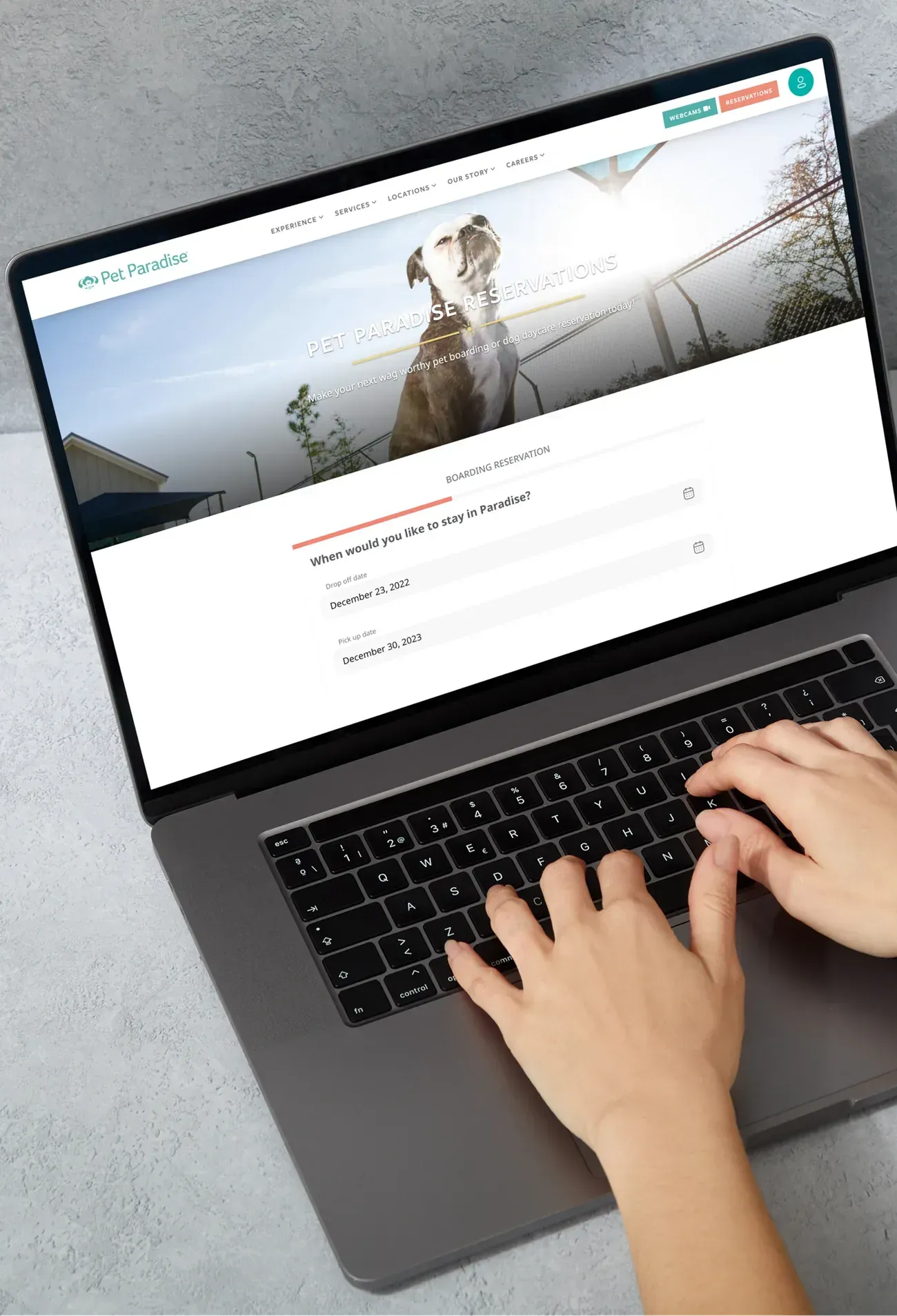 The Pet Paradise website booking page, shown on a laptop.