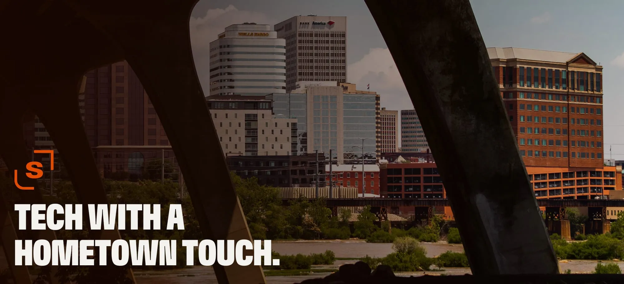 The Richmond skyline seen between the arches of a bridge, with the words "Tech with a hometown touch."