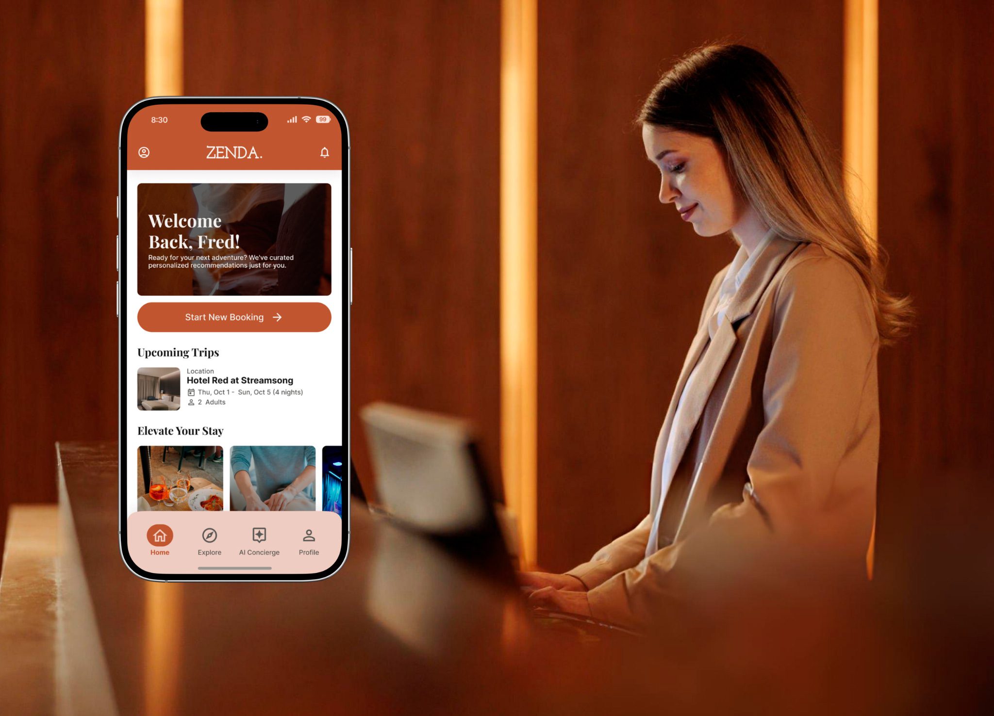 A woman in a tan coat stands at a warm wood-paneled reception counter, next to a smartphone displaying the Zenda app's home screen with a personalized welcome message and upcoming trip to Hotel Red at Streamsong.